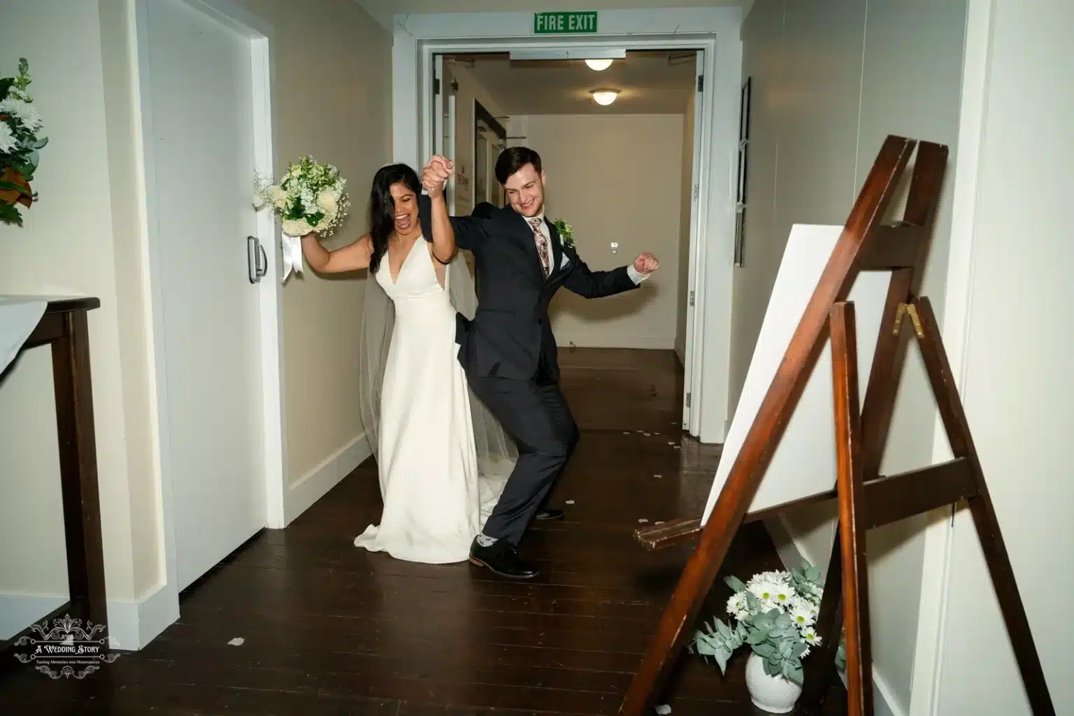 Bride and groom dancing joyfully in the wedding reception hall, holding hands and the bouquet.