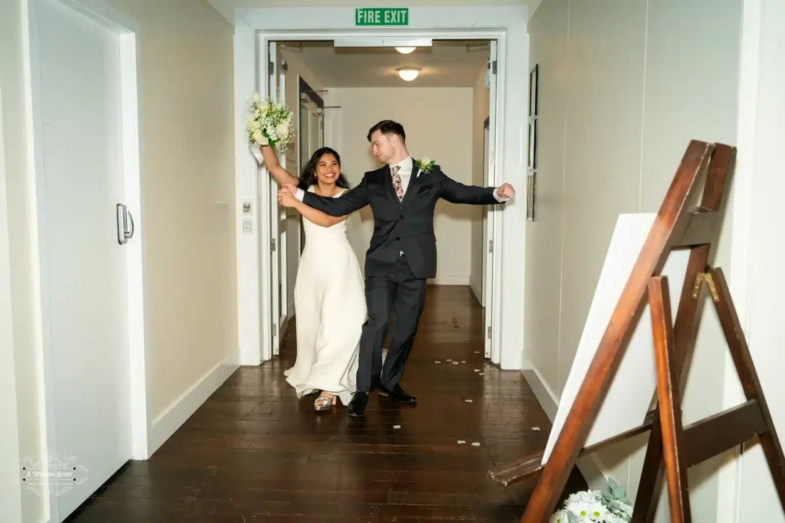 Bride and groom dancing through their wedding reception hall, bride holding Venue.