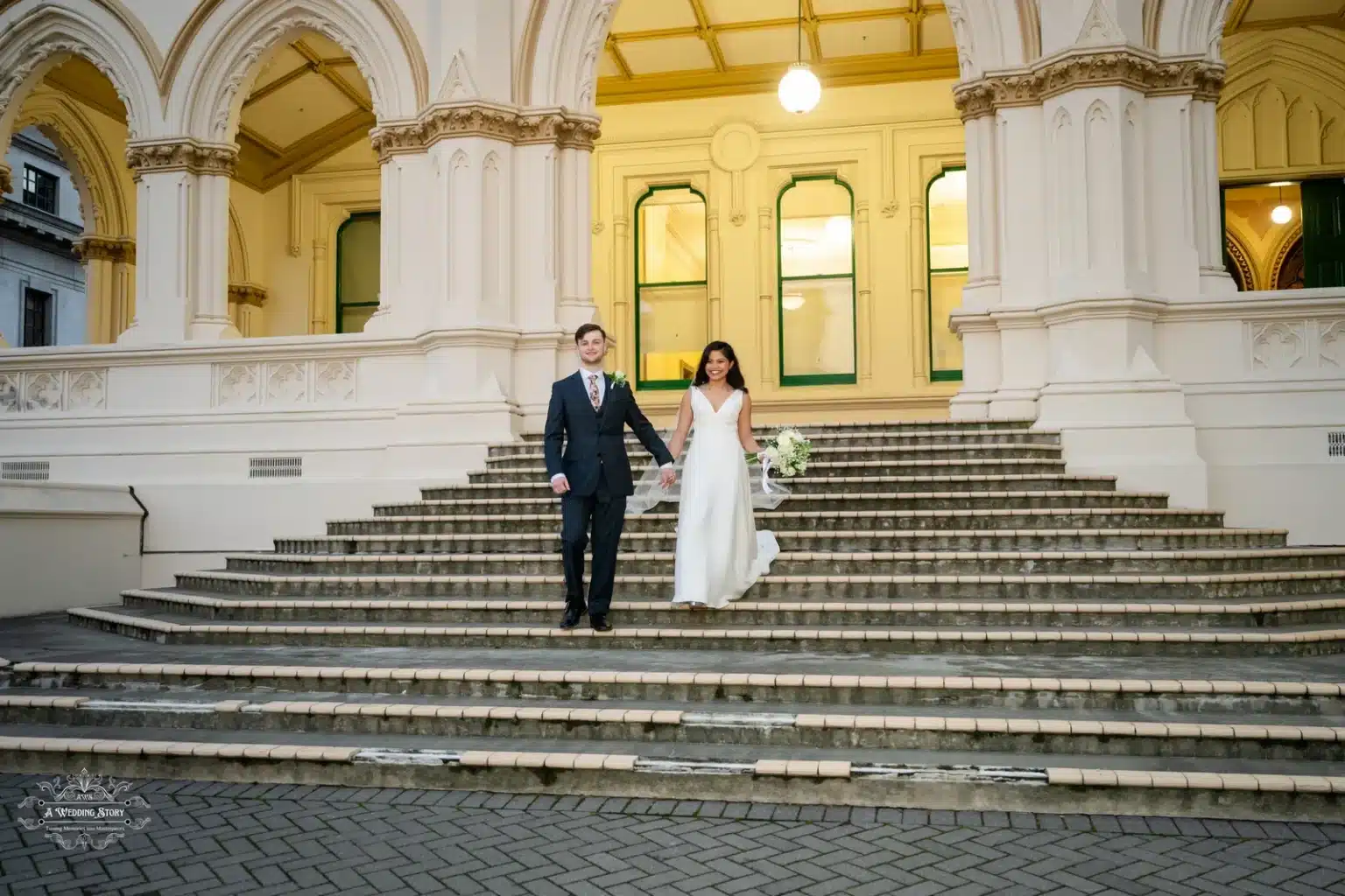 Bride and groom standing together on the historic steps of Wellington