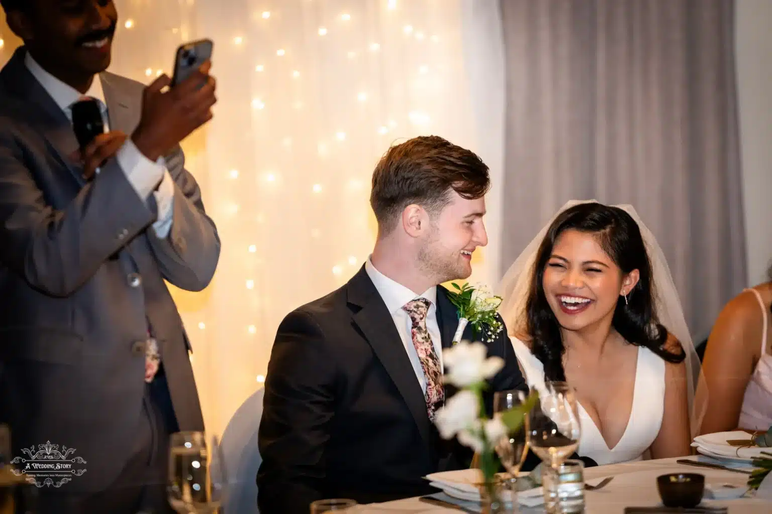 Bride and groom laughing during wedding reception toast in Wellington.