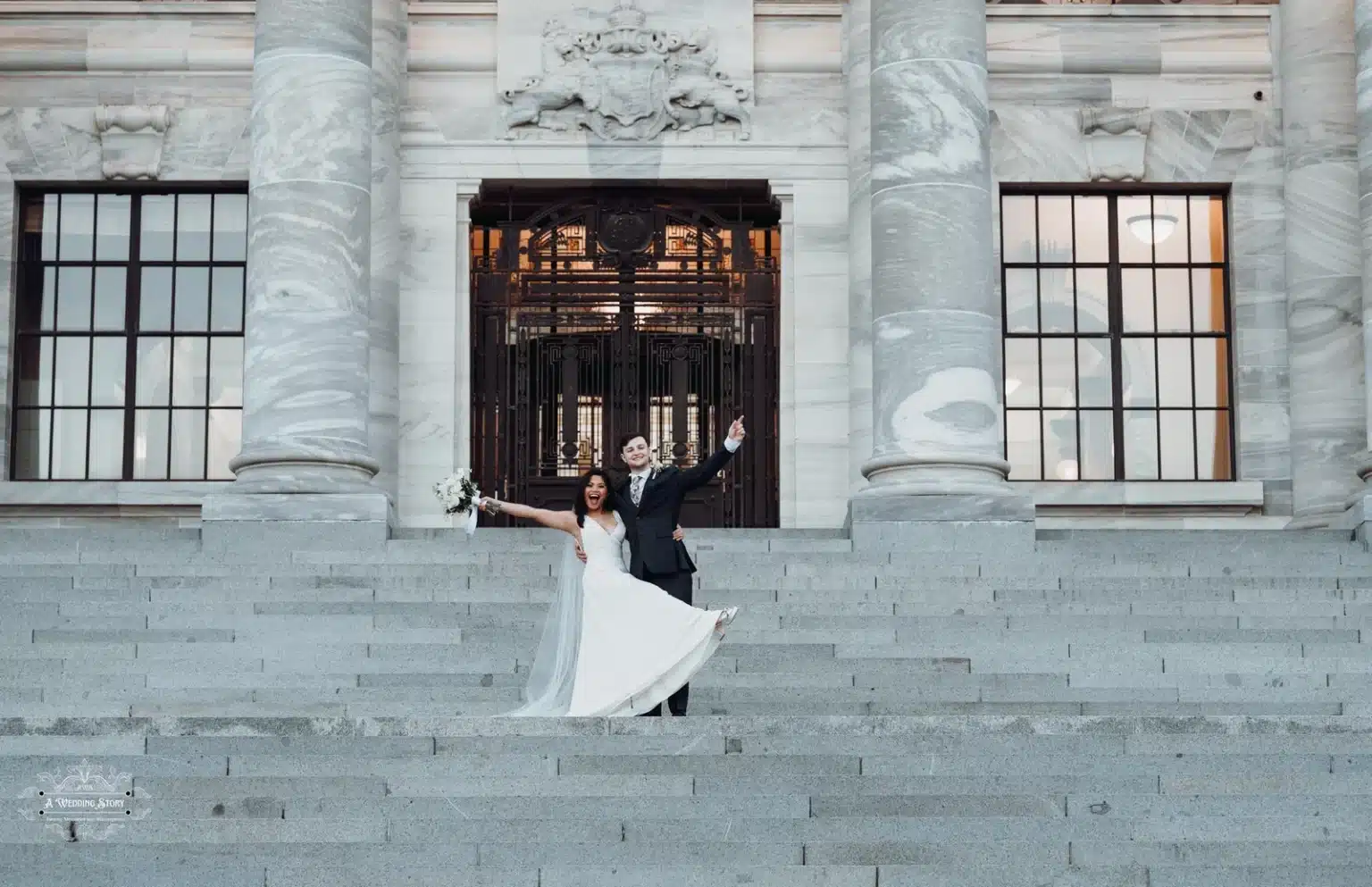 Bride and groom celebrating on the grand staircase of Wellington’s Parliament building.