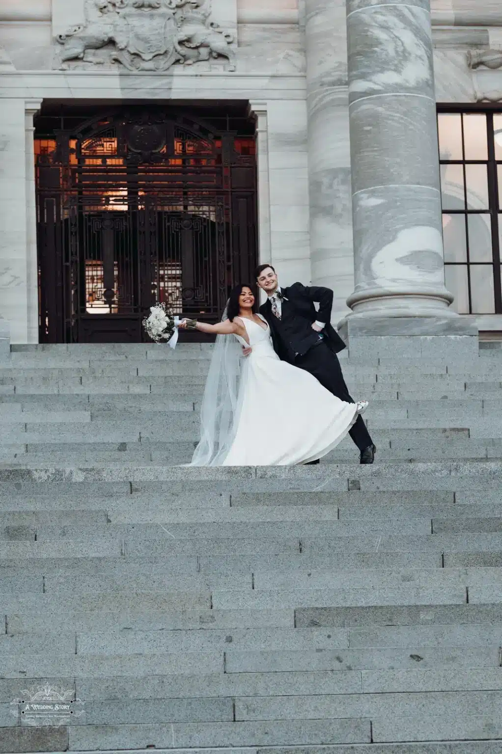 Bride and groom celebrating on the grand staircase of Wellington’s Parliament building.