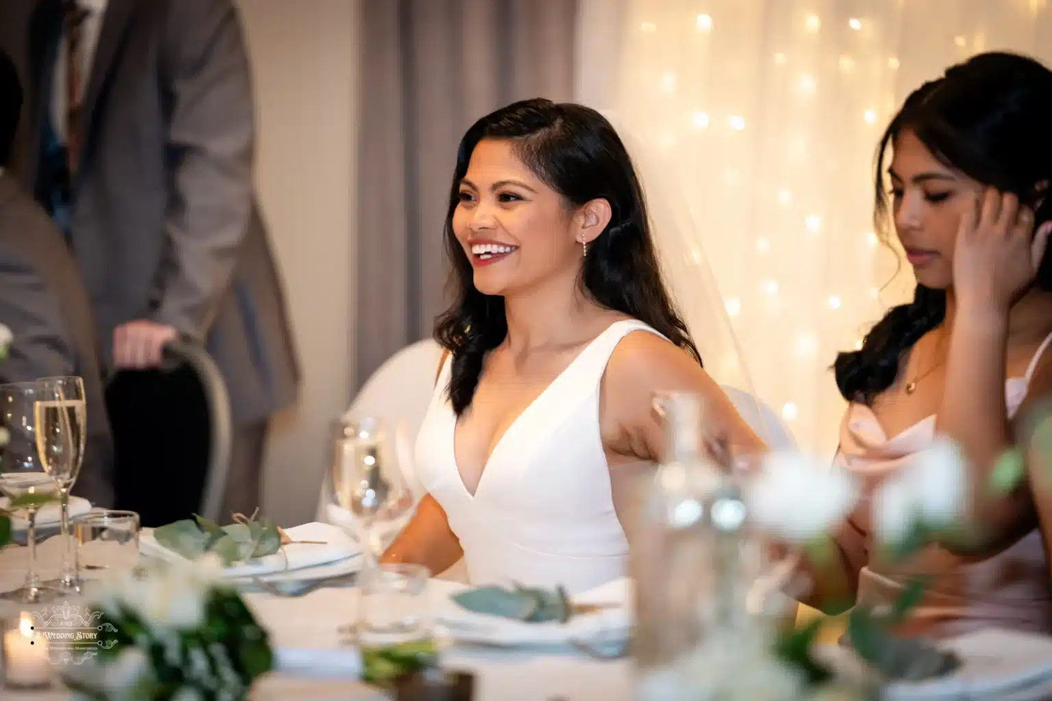 Bride smiling joyfully at her wedding reception in Wellington, New Zealand, with friends around her.