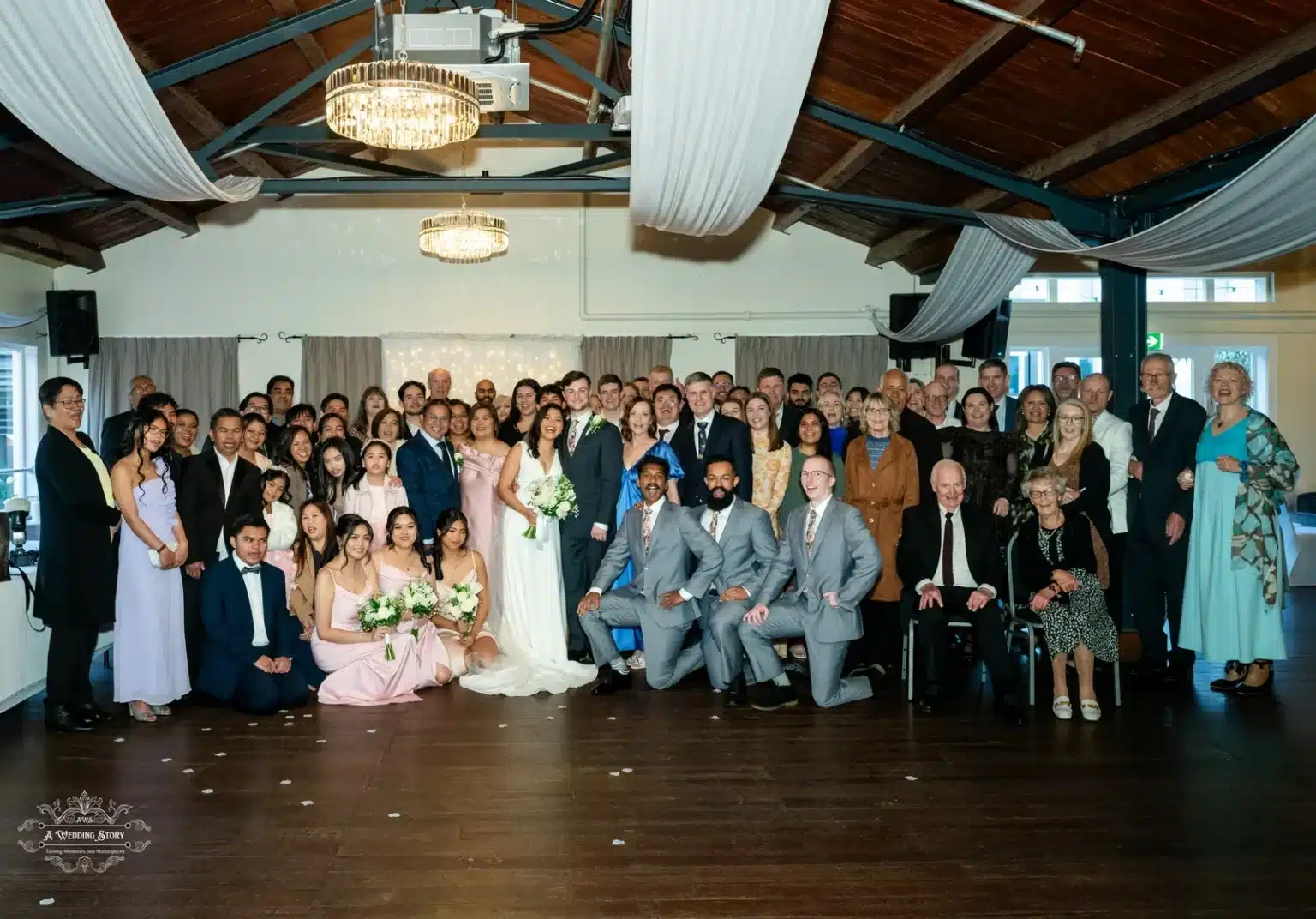 Full group photo of the bride and groom surrounded by family and friends at a wedding in Wellington.