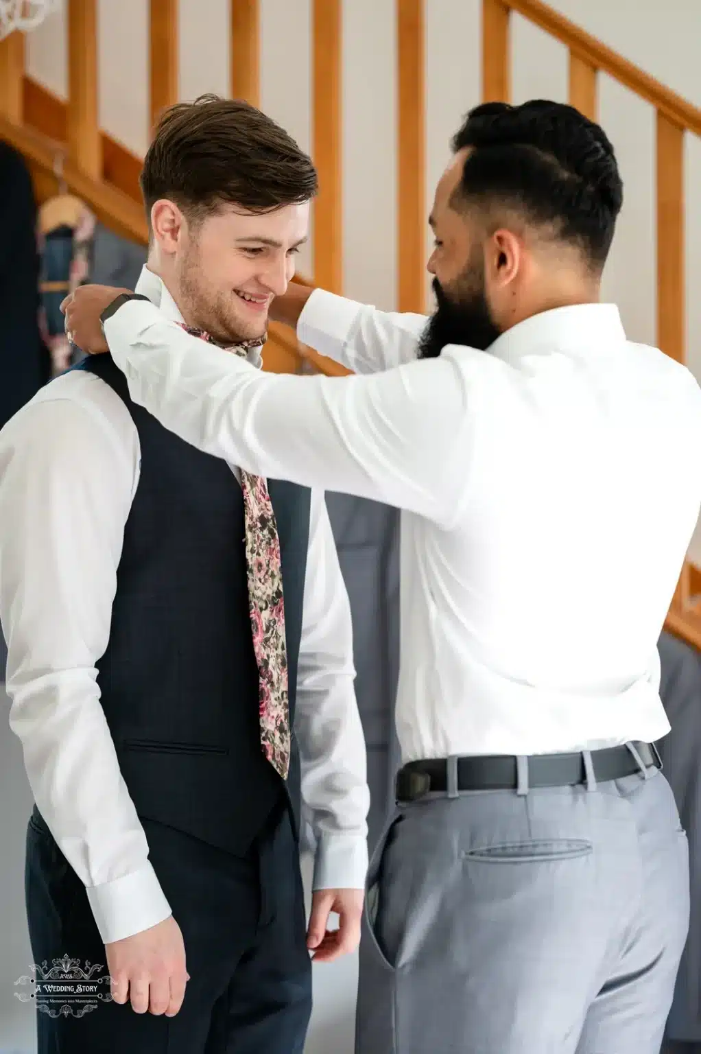 Groom being assisted with his tie by a groomsman in a candid preparation moment before the wedding ceremony in Wellington, New Zealand.