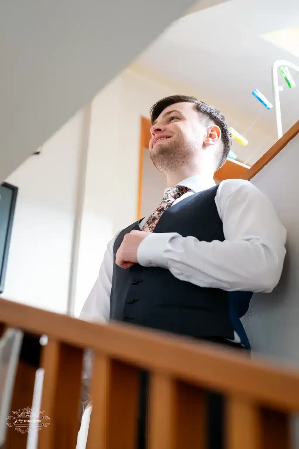 A groom adjusting his vest while preparing for his wedding day in Wellington, New Zealand.