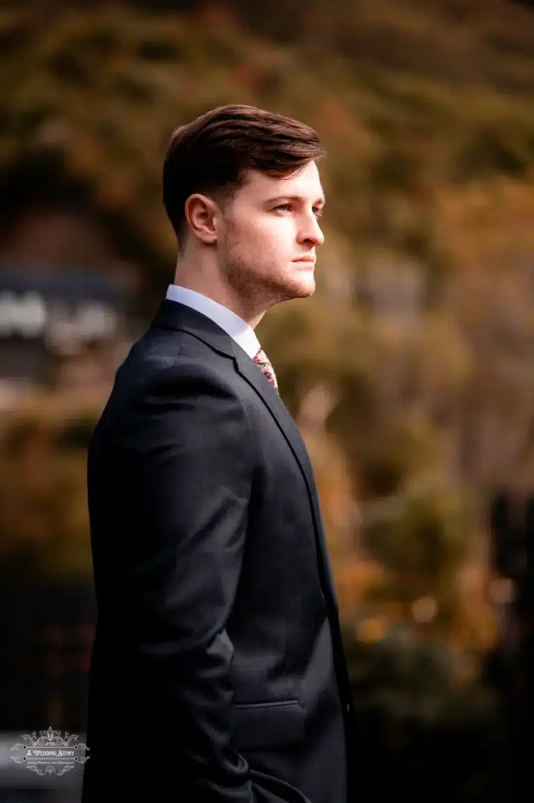 Groom in formal wedding attire captured in a profile shot in Wellington, New Zealand