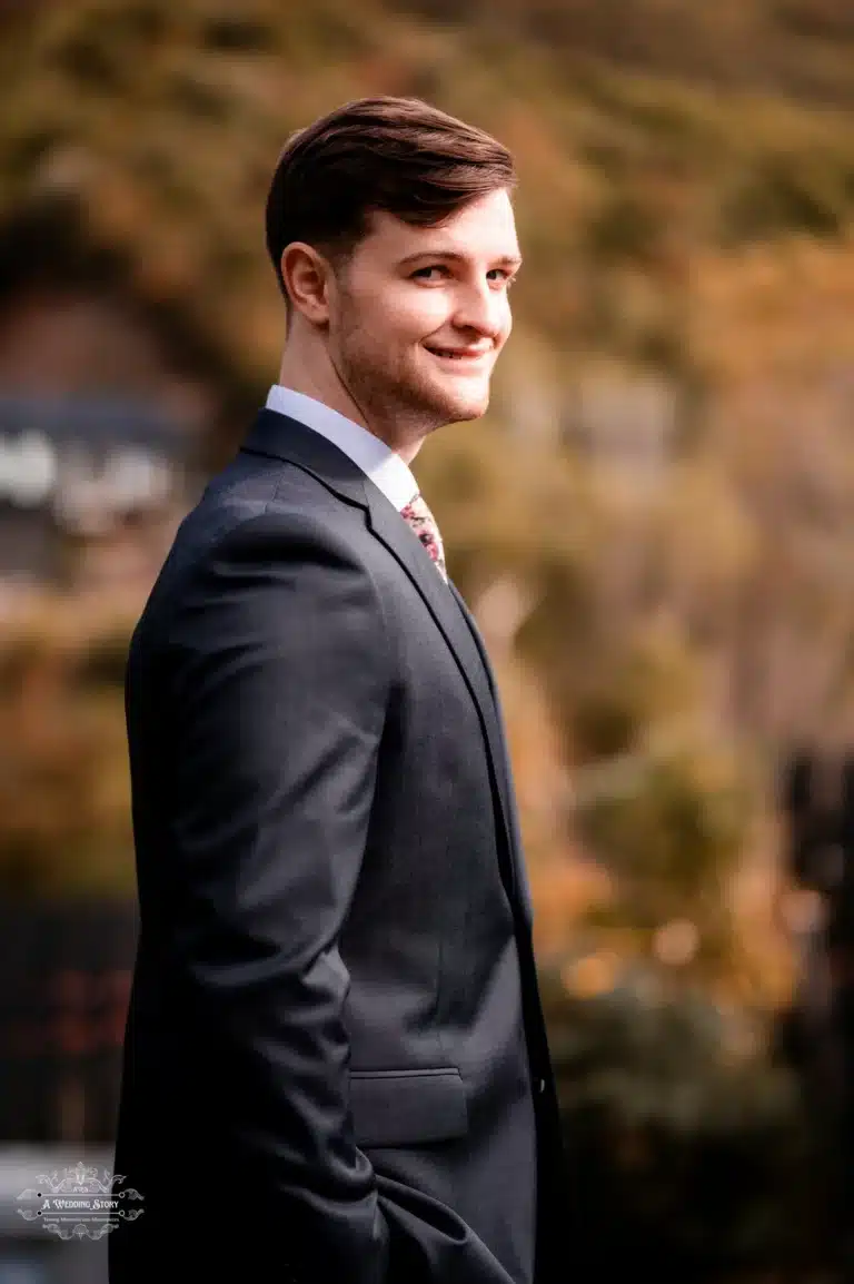 Groom smiling in a wedding suit at a wedding photoshoot.