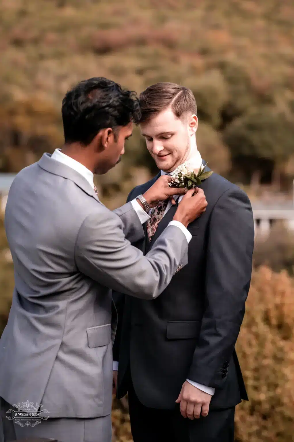 Groomsman fixing the boutonniere on the groom during an outdoor wedding in Wellington.