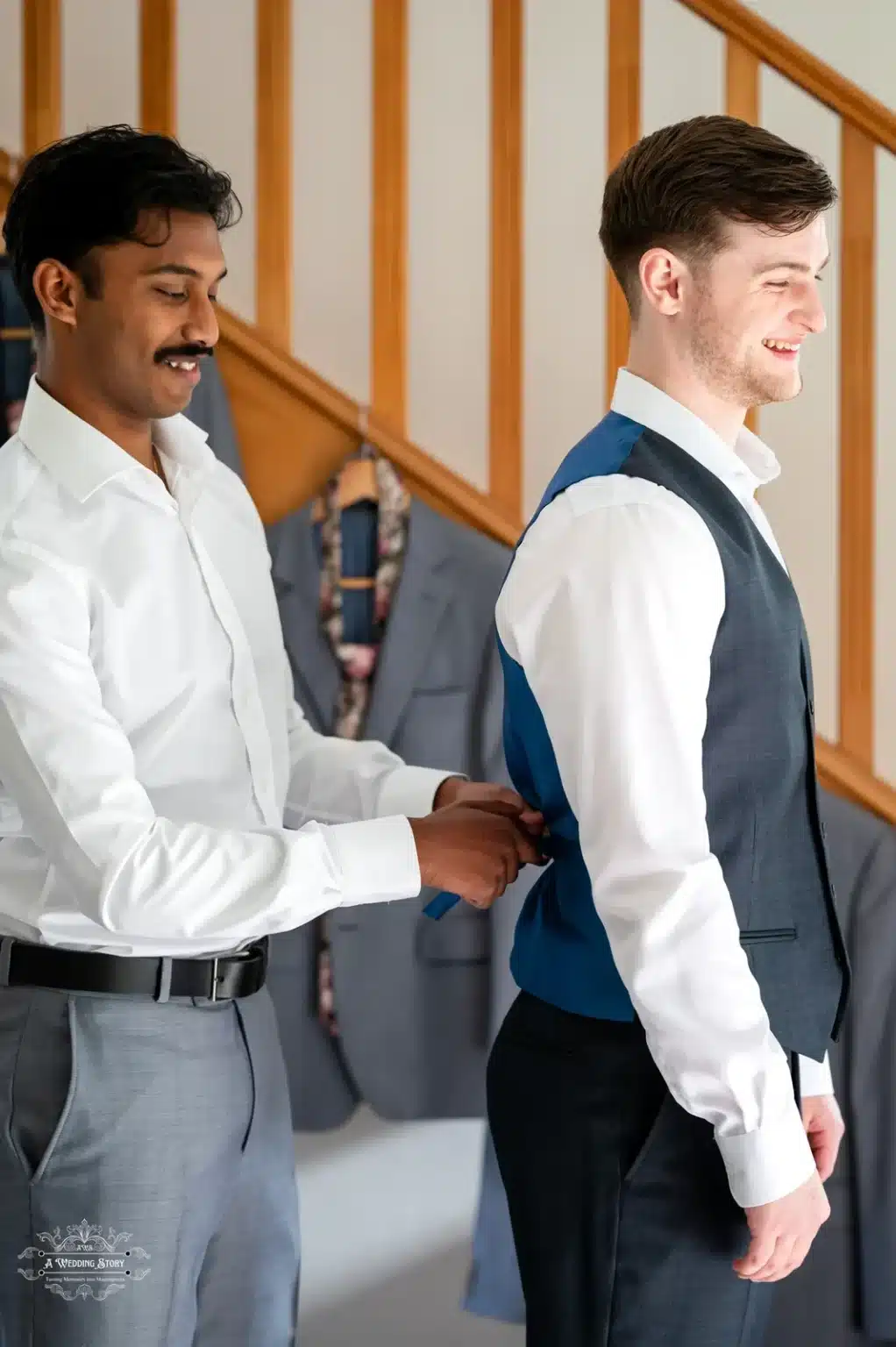 A groomsman adjusting the groom’s vest before the wedding ceremony in Wellington, New Zealand, capturing a candid preparation moment.