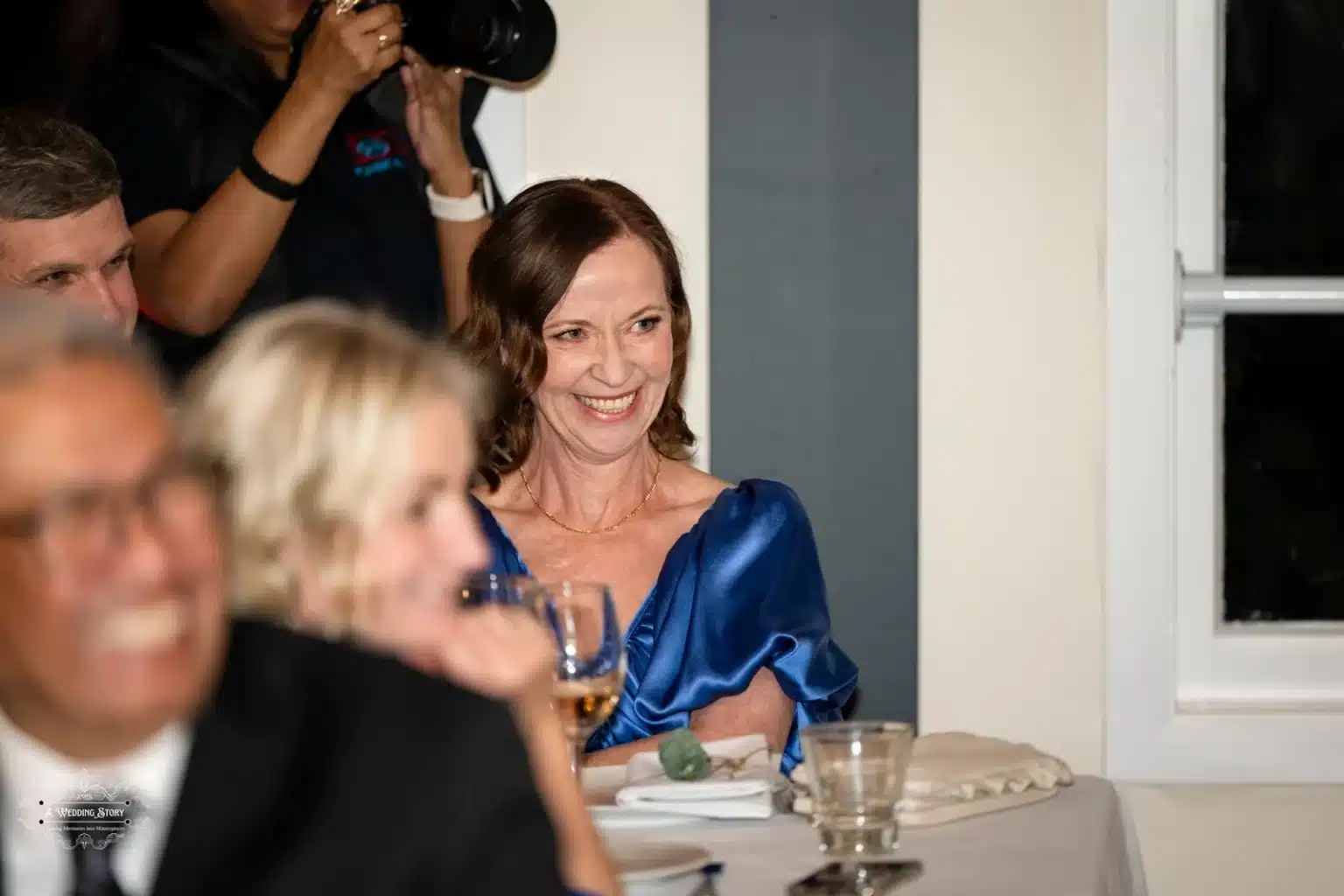 Guest enjoying the wedding reception in Wellington, New Zealand, smiling with a glass in hand.