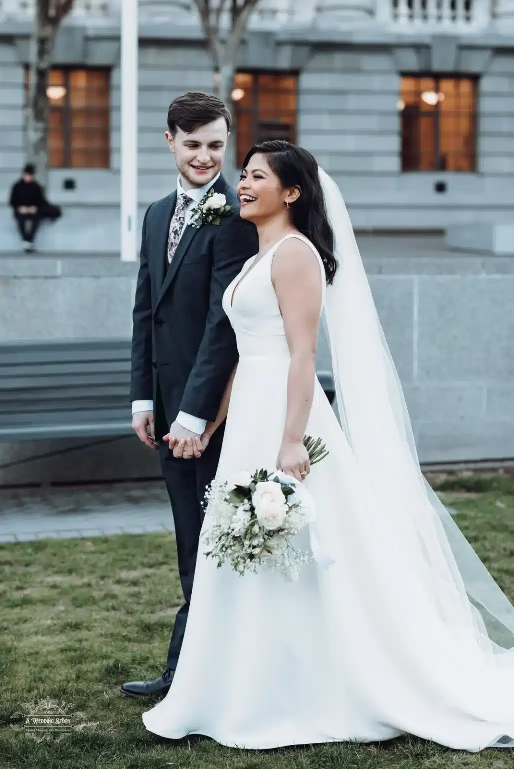 A joyful bride and groom holding hands in a serene outdoor setting in Wellington, New Zealand.