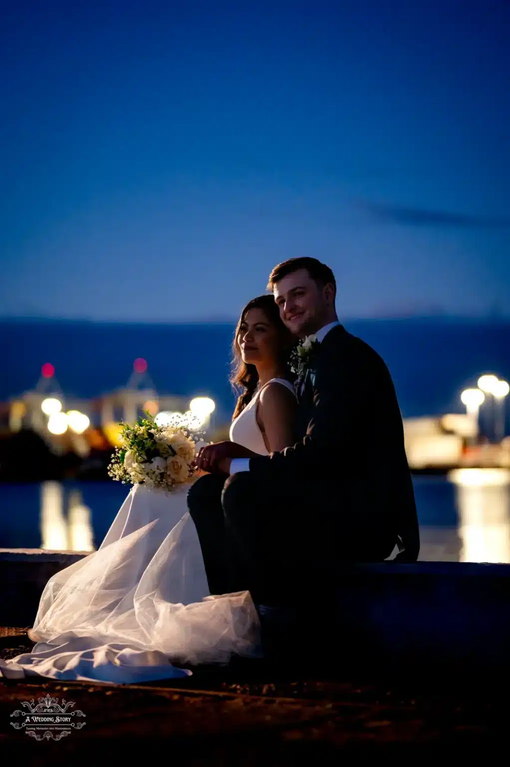 Bride and groom sitting together at dusk, showcasing their love in a serene outdoor wedding scene in Wellington.