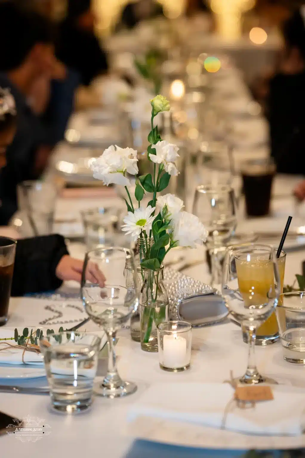 Wedding reception table decor with flowers and glasses at a Wellington wedding.