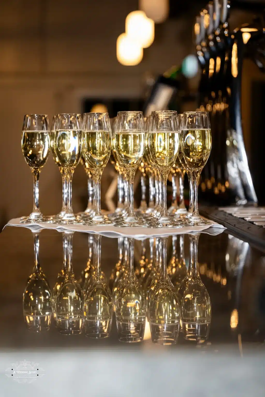 A row of champagne glasses lined up for a toast at a wedding celebration.