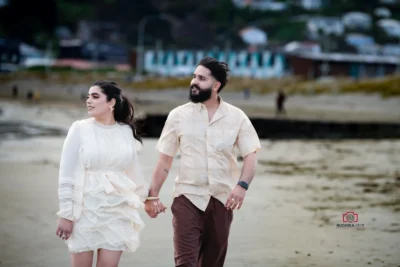 Bride and groom walking hand-in-hand along the shore during their beach Wedding in Hawke's Bay