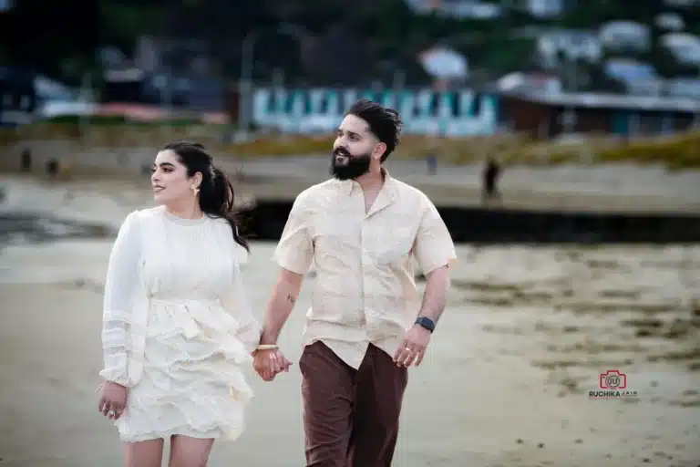 Bride and groom walking hand-in-hand along the shore during their beach Wedding in Hawke's Bay