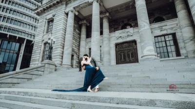 Couple sharing a romantic dip on the grand steps of a historic building in Wellington