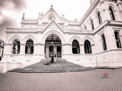 Bride and groom standing on grand steps with dramatic architecture in Wellington for their elopement