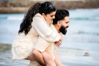 Bride playfully on groom’s back by the beach during their Wellington elopement