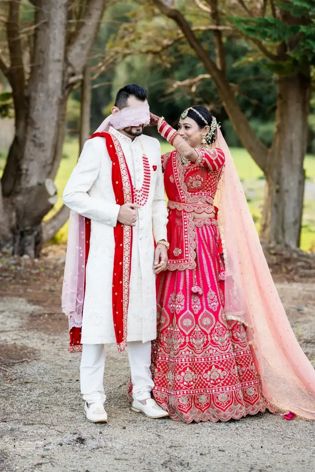 Playful Gujarati bride covering the groom’s eyes with her dupatta during their wedding photoshoot in Wellington, New Zealand.