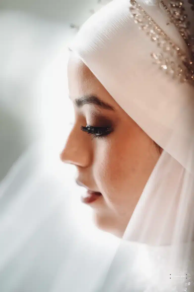 Close-up of Afghan bride in a white hijab with intricate headpiece, captured in profile on her wedding day in Wellington.