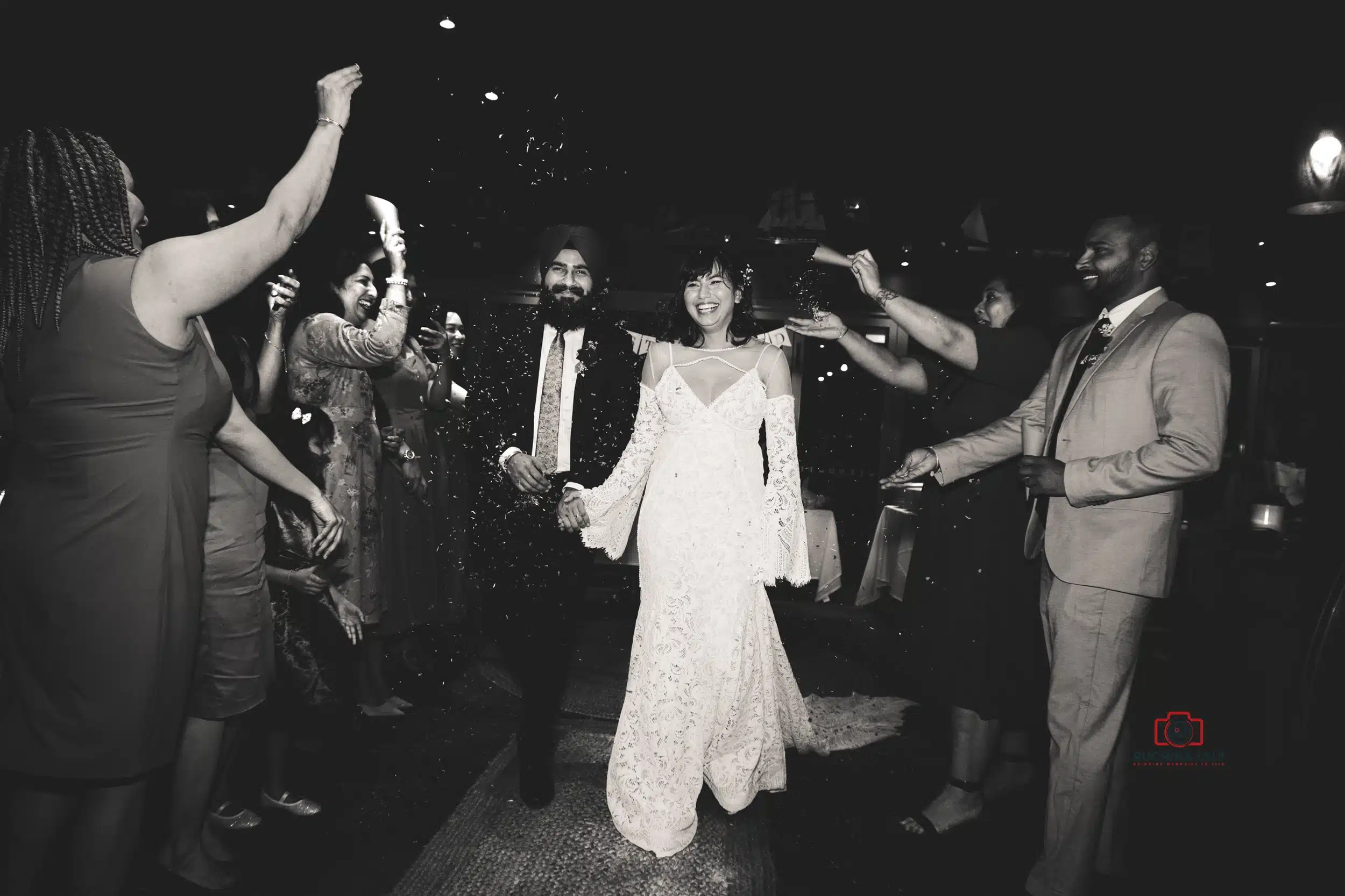 Bride and groom exiting their wedding ceremony, smiling as guests celebrate around them