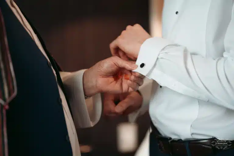 Close-up of Afghan groom’s cufflink being adjusted by an elder family member before his wedding in Wellington.