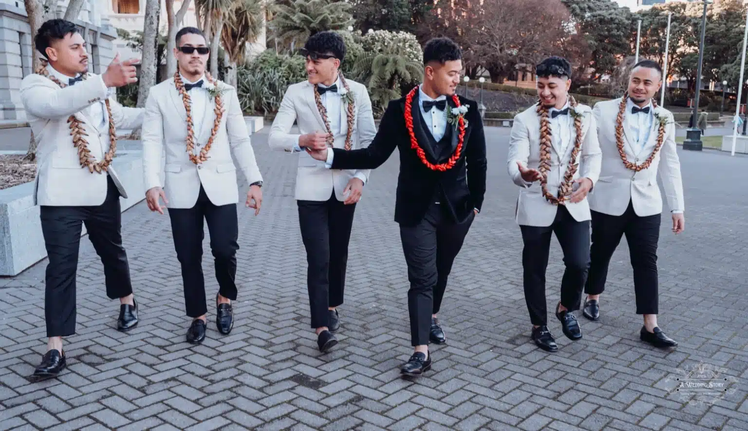 Groom and groomsmen sharing smiles and conversations while walking together during a relaxed wedding photoshoot in Wellington, New Zealand.