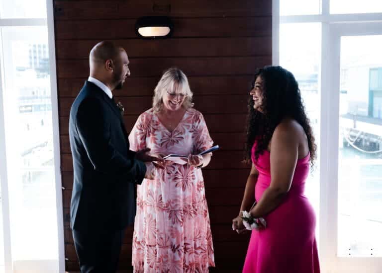 A couple exchanging wedding vows in an intimate ceremony with their celebrant, surrounded by natural light, captured by a professional wedding photographer in Wellington