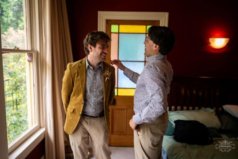 Groom sharing a joyful moment with a friend before his wedding in Carterton, New Zealand