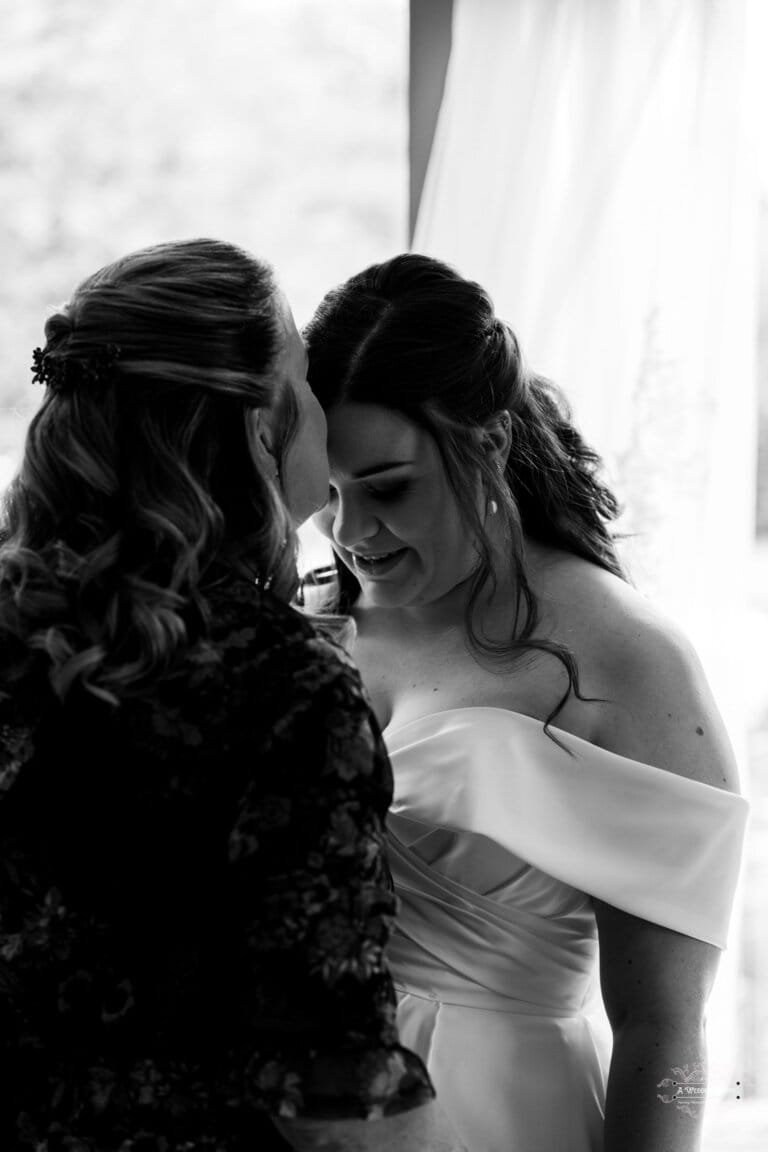 Black and white photo of a bride sharing a heartfelt moment with her mother before the wedding in Carterton, New Zealand