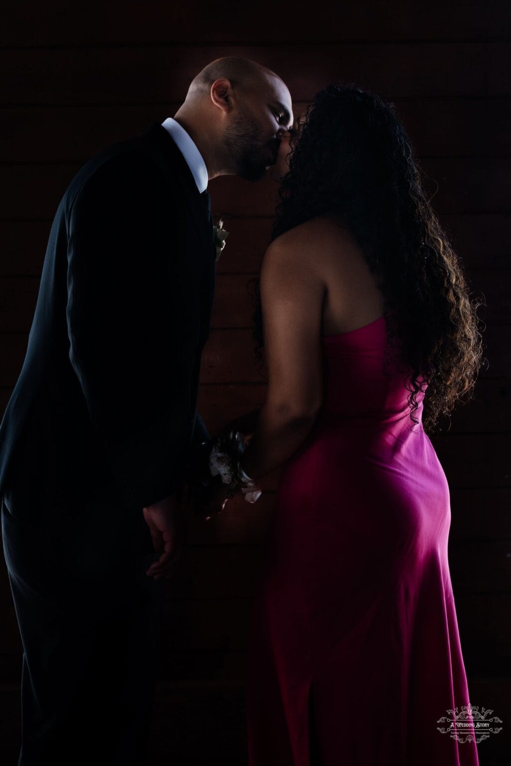 A newlywed couple sharing a romantic first kiss in a beautifully lit, intimate setting, captured by a Wellington wedding photographer