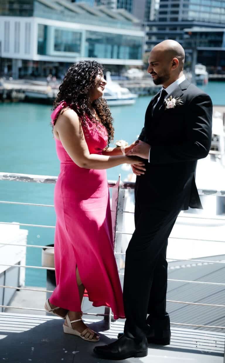 A romantic wedding moment by the waterfront, capturing the couple exchanging heartfelt glances, beautifully documented by a Wellington wedding photographer.