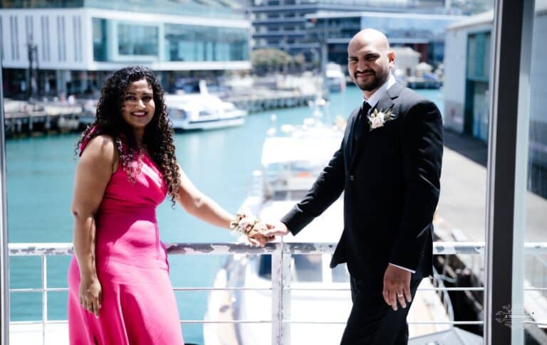 A newlywed couple sharing a heartfelt moment at their waterfront wedding venue, beautifully captured by a professional Wellington wedding photographer.