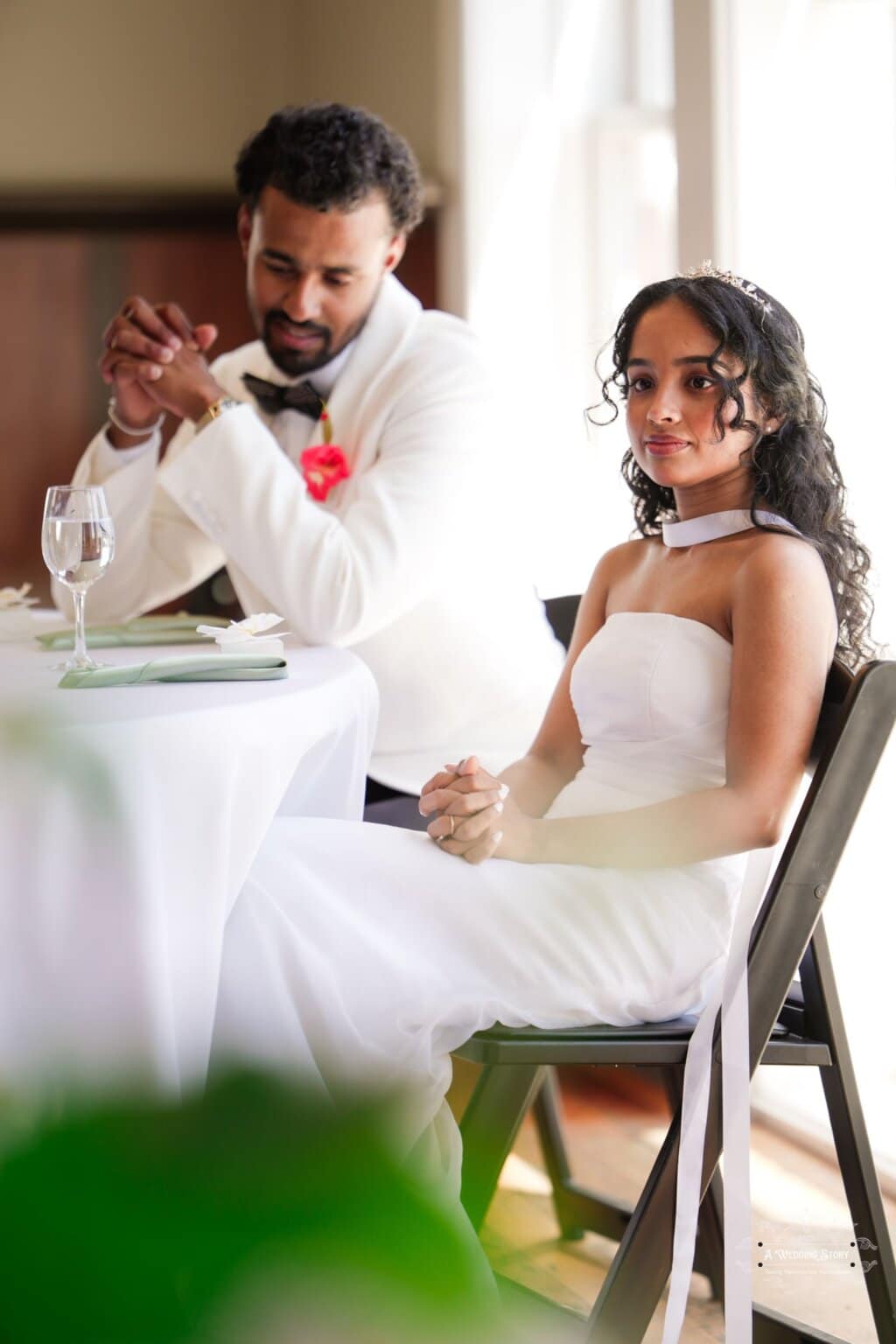 A newlywed couple at their wedding reception in Wellington, with the bride in a white gown and the groom in a white tuxedo