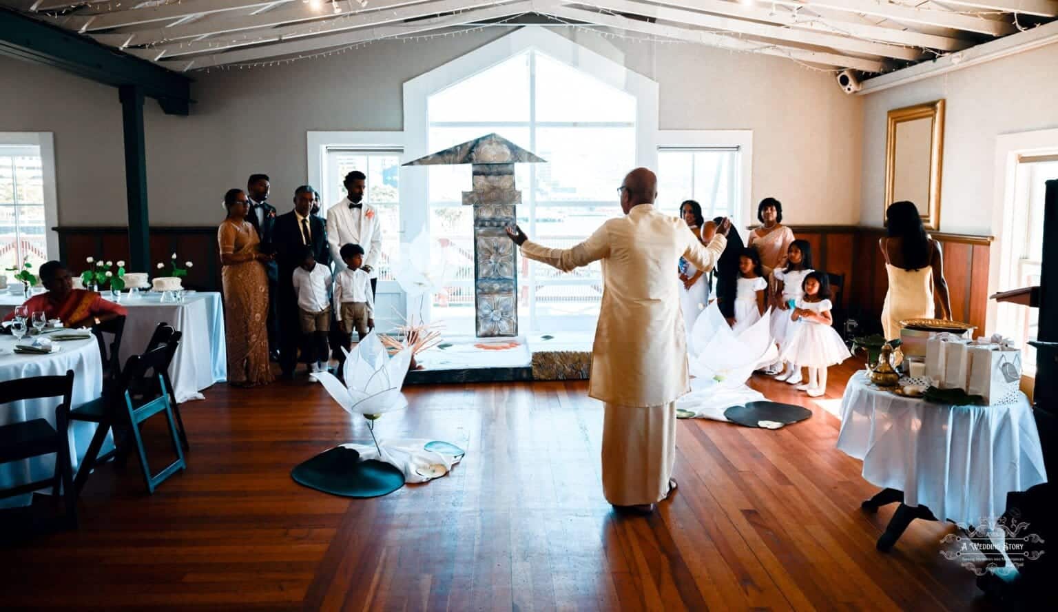 A wedding ceremony in Wellington featuring a traditional ritual with family members and guests gathered in a beautifully decorated venue