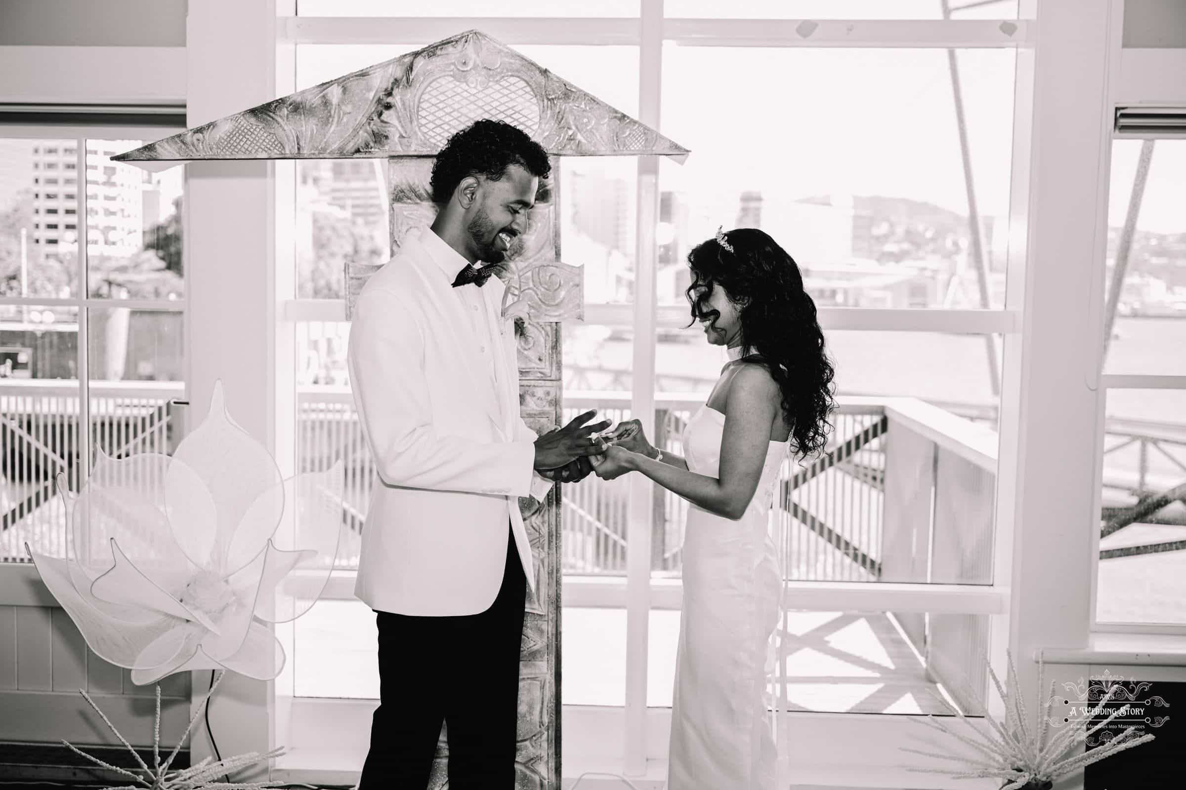 A groom and bride exchanging wedding rings during their intimate indoor wedding ceremony in Wellington