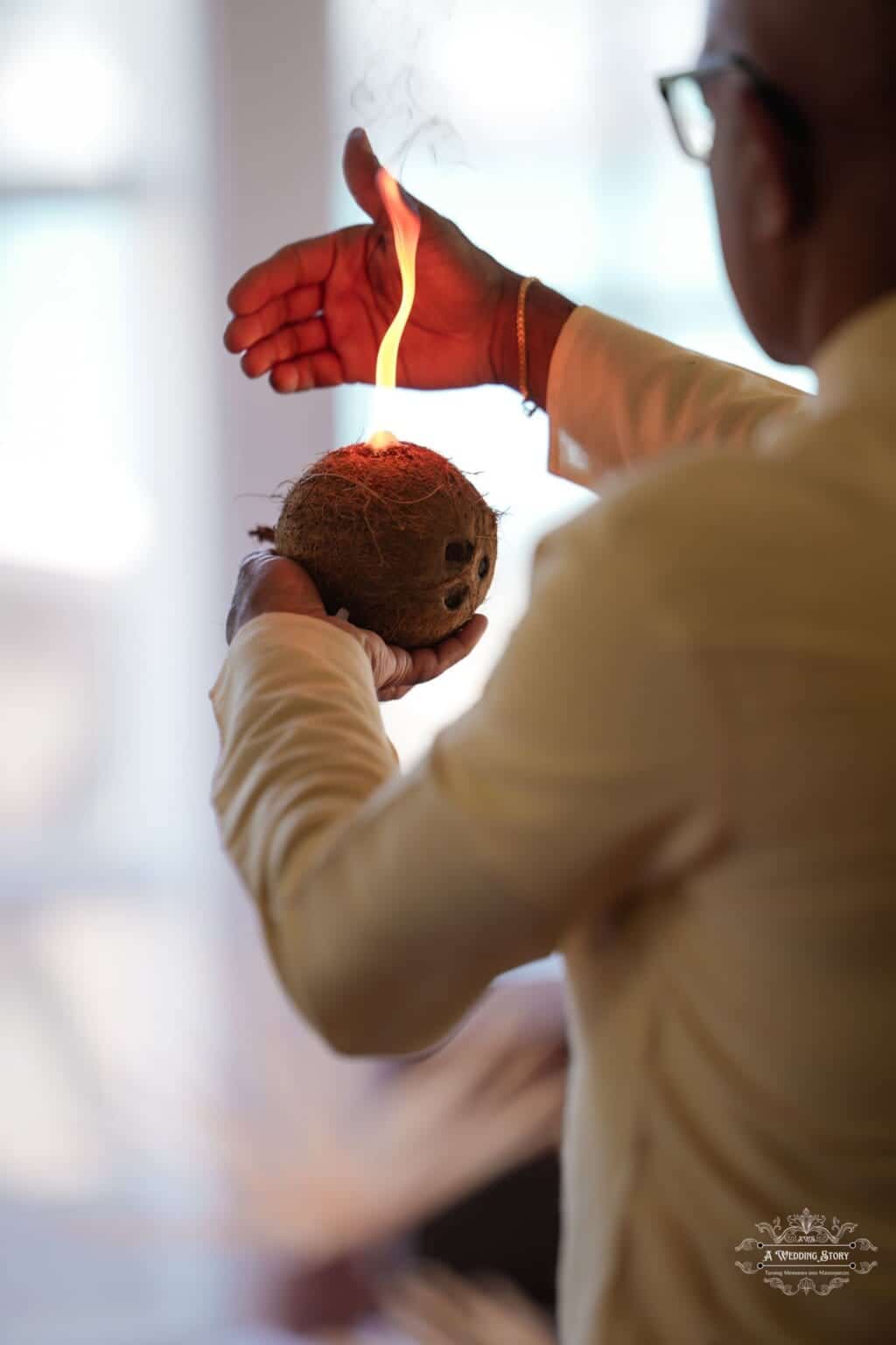 A priest performs a sacred wedding ritual holding a burning coconut as part of a traditional ceremony in Wellington