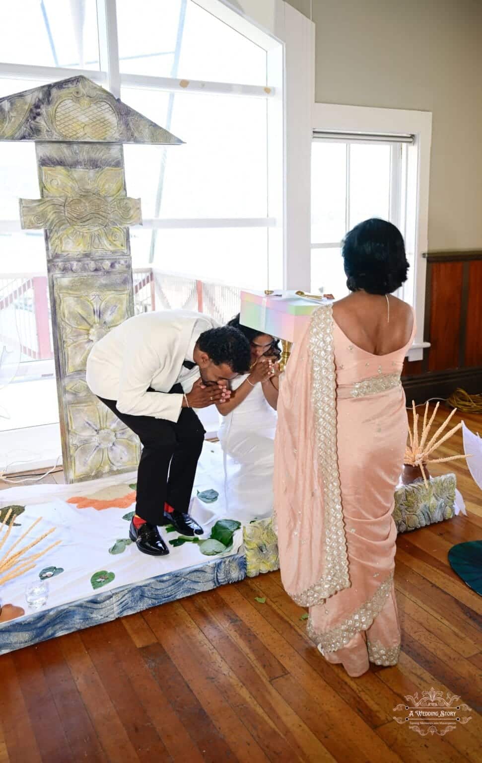 A bride and groom receiving a heartfelt blessing from a family elder during a cultural wedding ceremony in Wellington