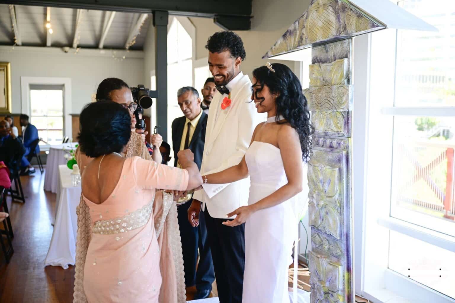 A bride and groom receive a traditional blessing from a family elder during their wedding ceremony in Wellington, New Zealand