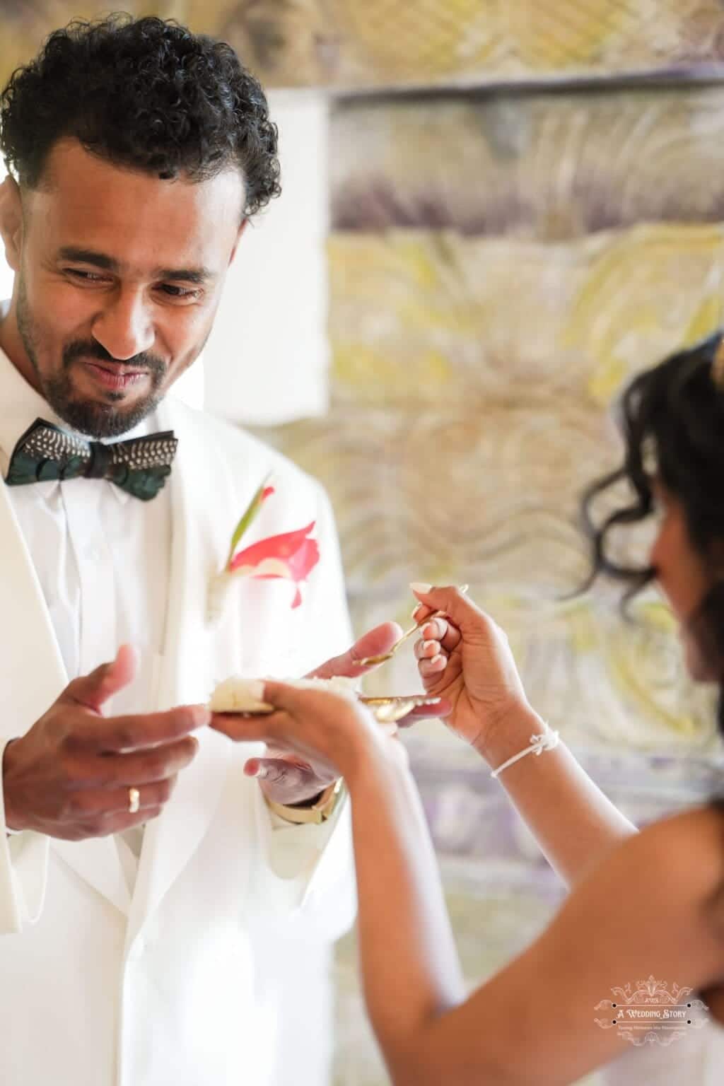 Bride offering a symbolic wedding ritual to the groom, holding a golden spoon with rice during a traditional wedding ceremony