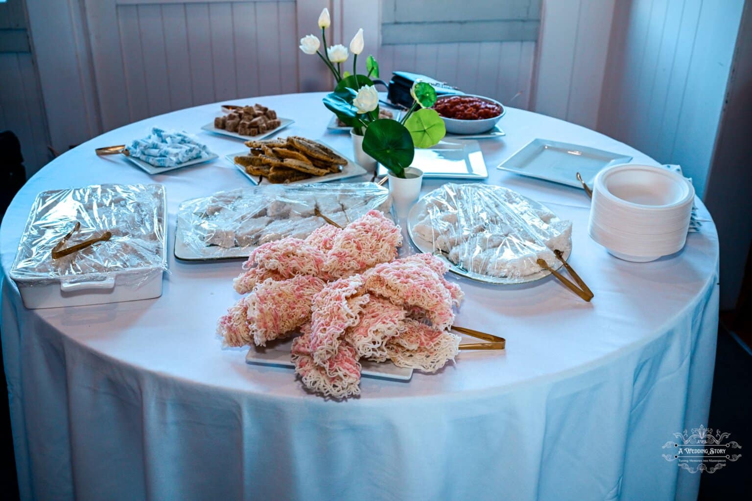 A beautifully arranged wedding sweets table featuring traditional desserts, decorative floral accents, and an elegant setting at a Wellington wedding