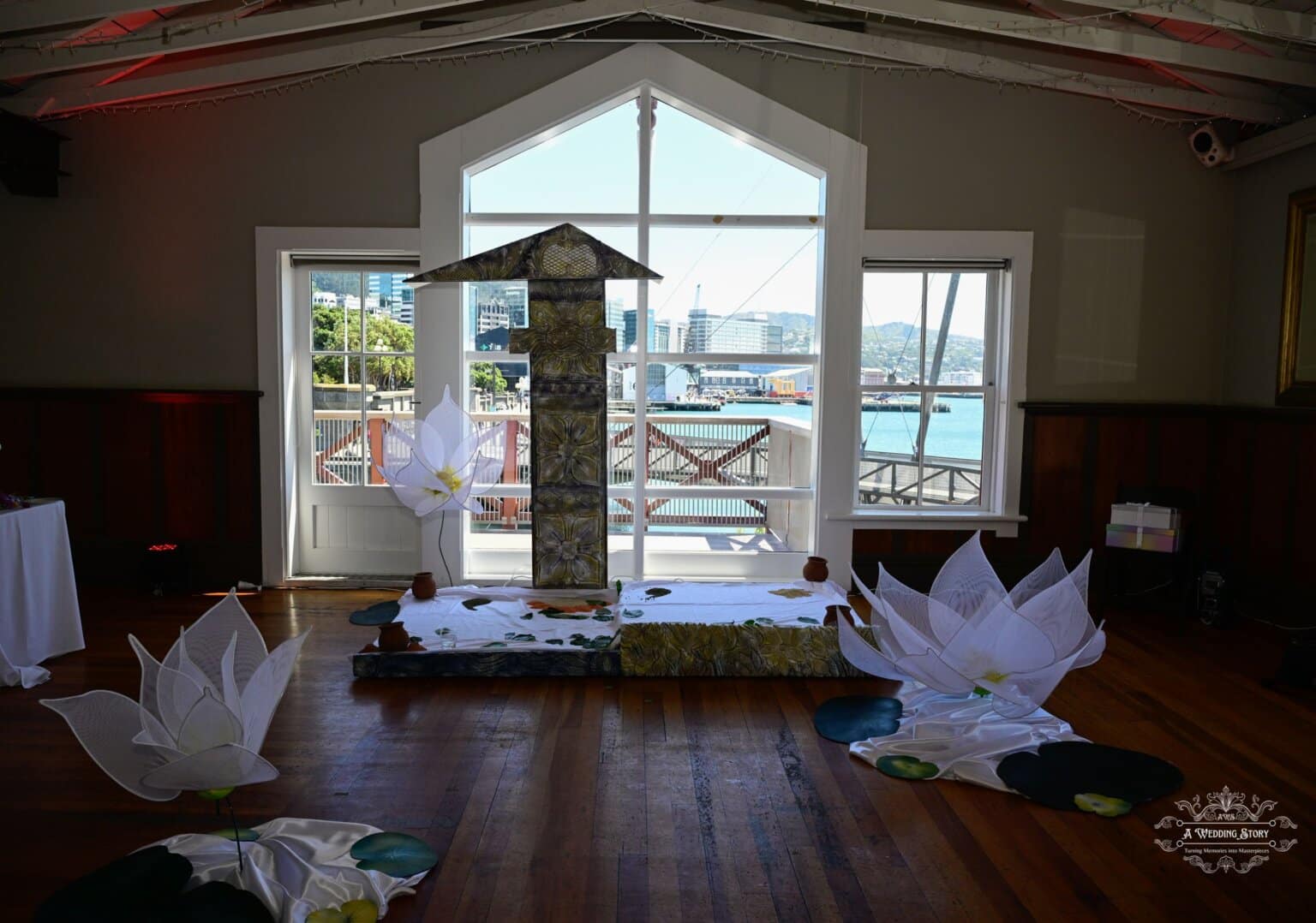 Beautifully arranged wedding ceremony setup in Wellington, featuring cultural elements, intricate floral designs, and a stunning waterfront view