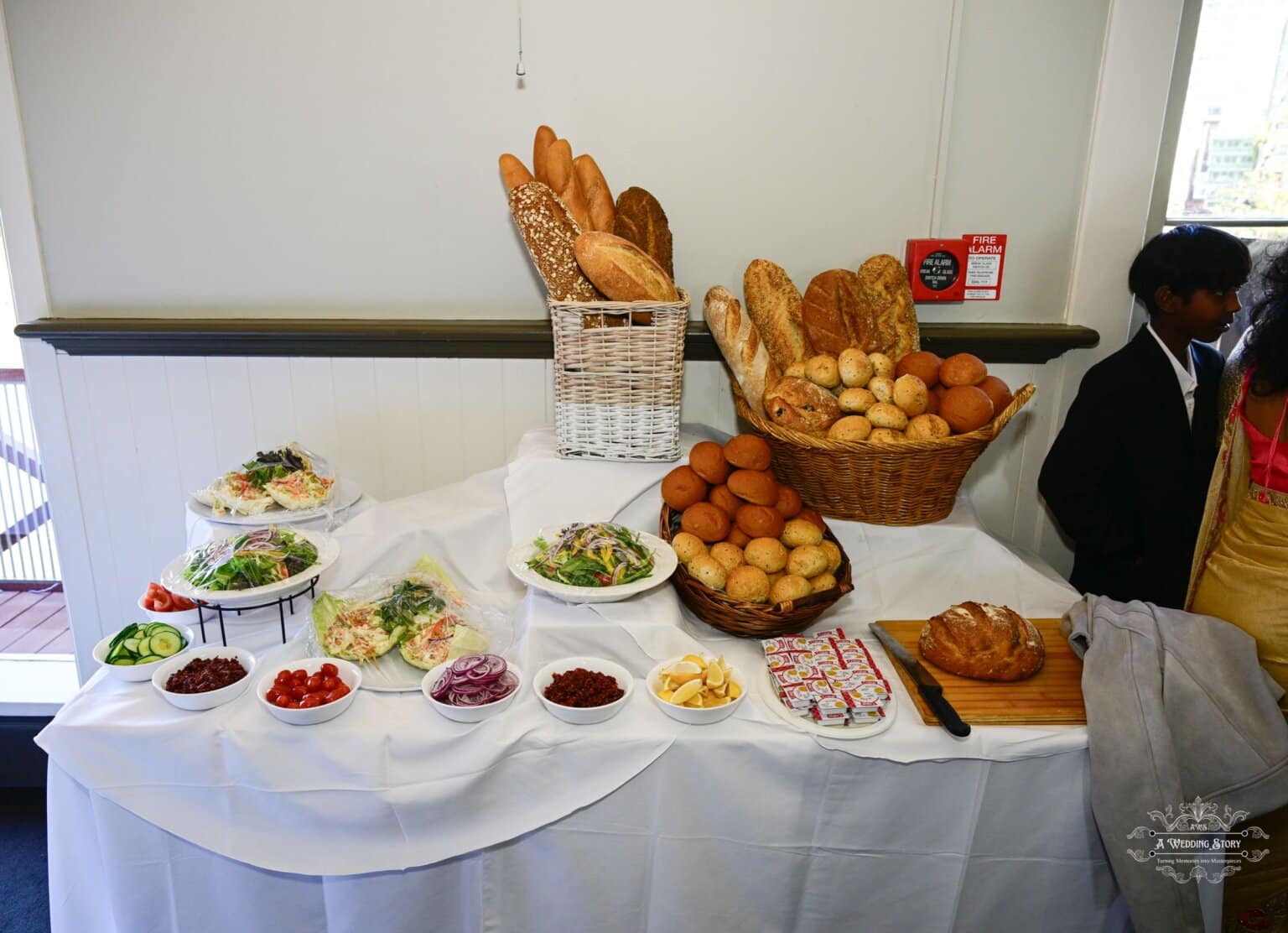 A beautifully arranged wedding buffet in Wellington, featuring an assortment of fresh bread, salads, and appetizers for guests