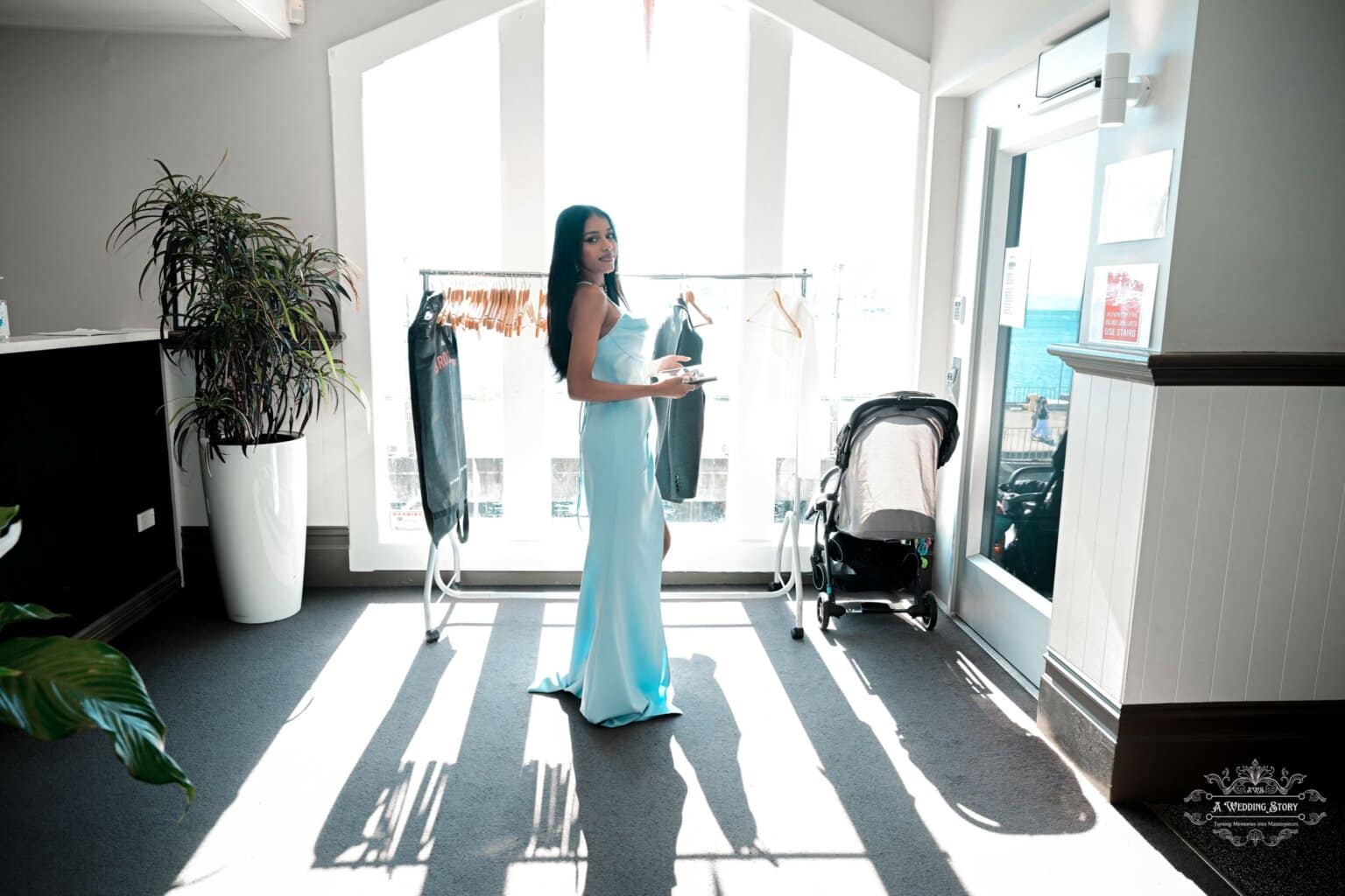 A bridesmaid in a stunning blue gown prepares for a wedding ceremony in Wellington, New Zealand