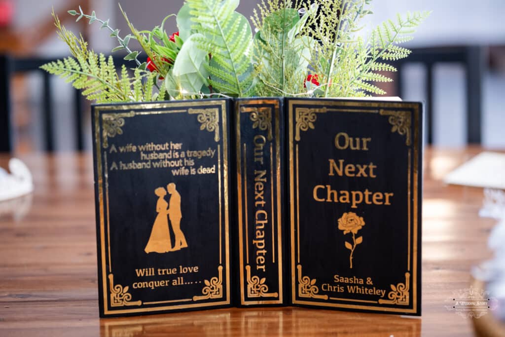 Wedding table decor featuring a book-inspired centerpiece with “Our Next Chapter” message at The Lodge Pāuatahanui Wellington