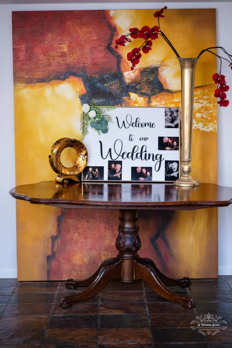 Wedding welcome table decor with personalized photo collage and vibrant floral arrangement at The Lodge Pāuatahanui Wellington